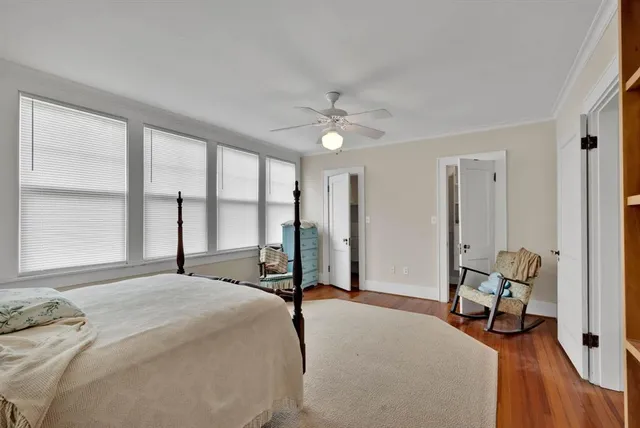 a bedroom with a bed and large windows