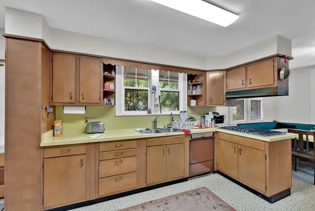 a kitchen with a sink stove and cabinets