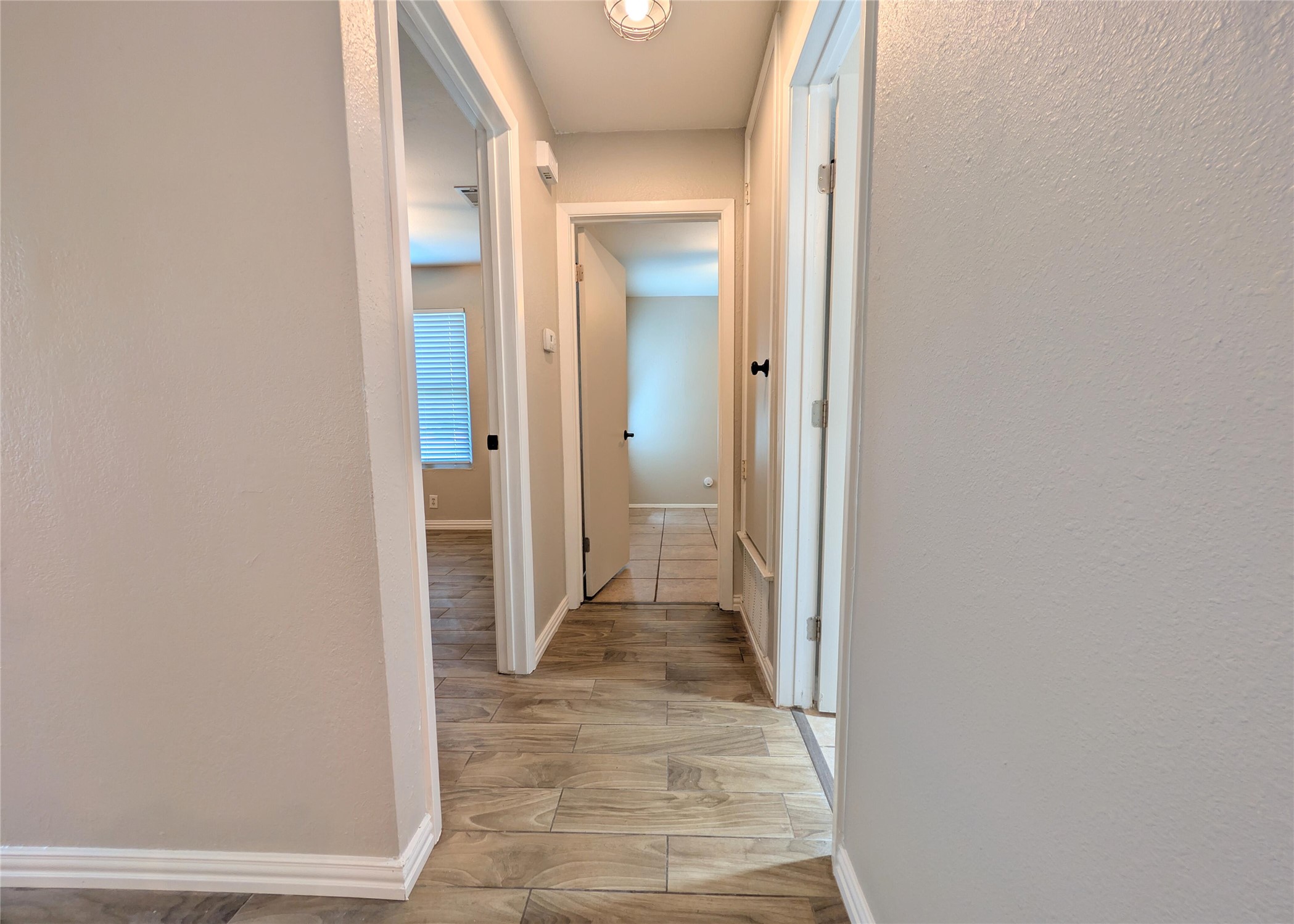 12601 Turtle Rock Road, Unit B Austin, TX 78729 - Photo 9 of 20 Hallway on left side when walking in front door (towards the street) that connects the other 2 bedrooms and bathroom to the living area.