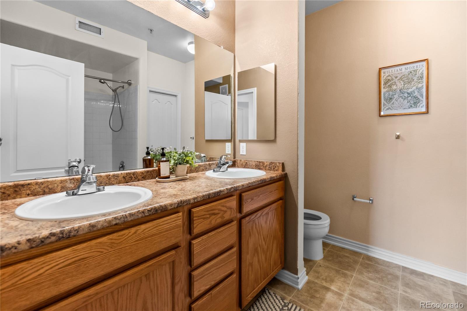 18669 Stroh Road, Unit 10204 Parker, CO 80134 - Photo 19 of 24 a bathroom with a double vanity sink and a mirror