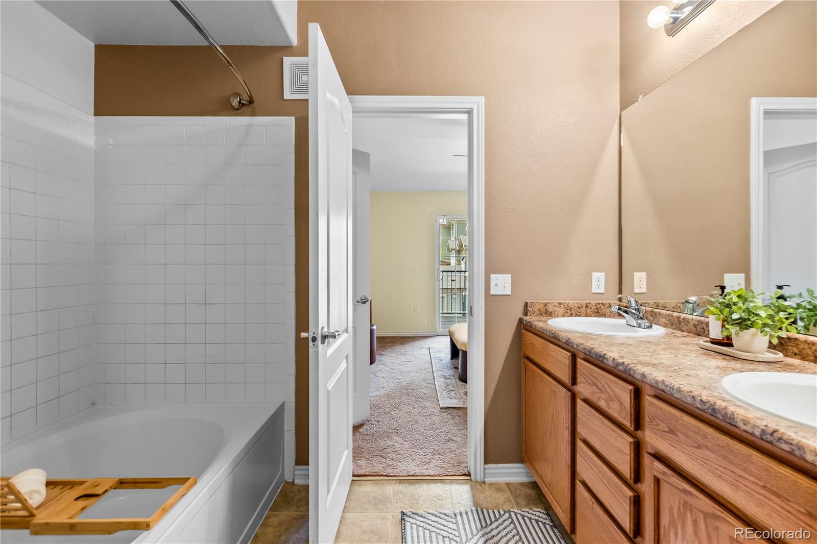 18669 Stroh Road, Unit 10204 Parker, CO 80134 - Photo 20 of 24 a bathroom with a granite countertop sink and a bathtub