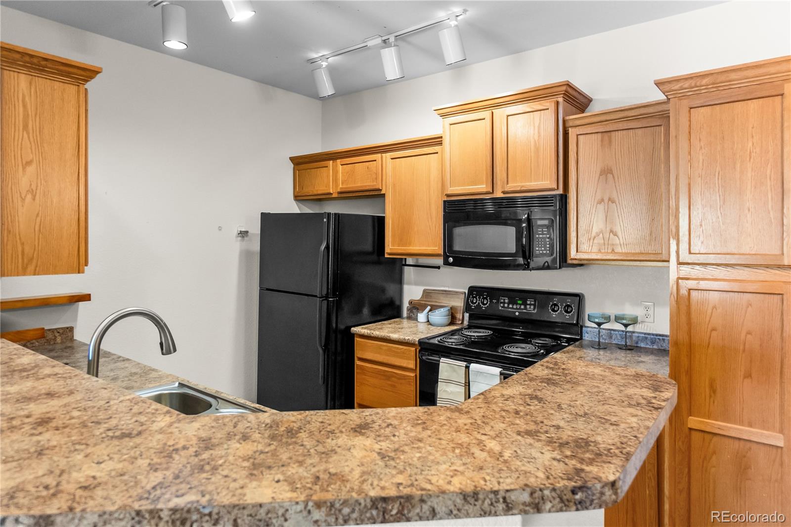 18669 Stroh Road, Unit 10204 Parker, CO 80134 - Photo 9 of 24 a kitchen with a refrigerator a stove a sink a window and dining table