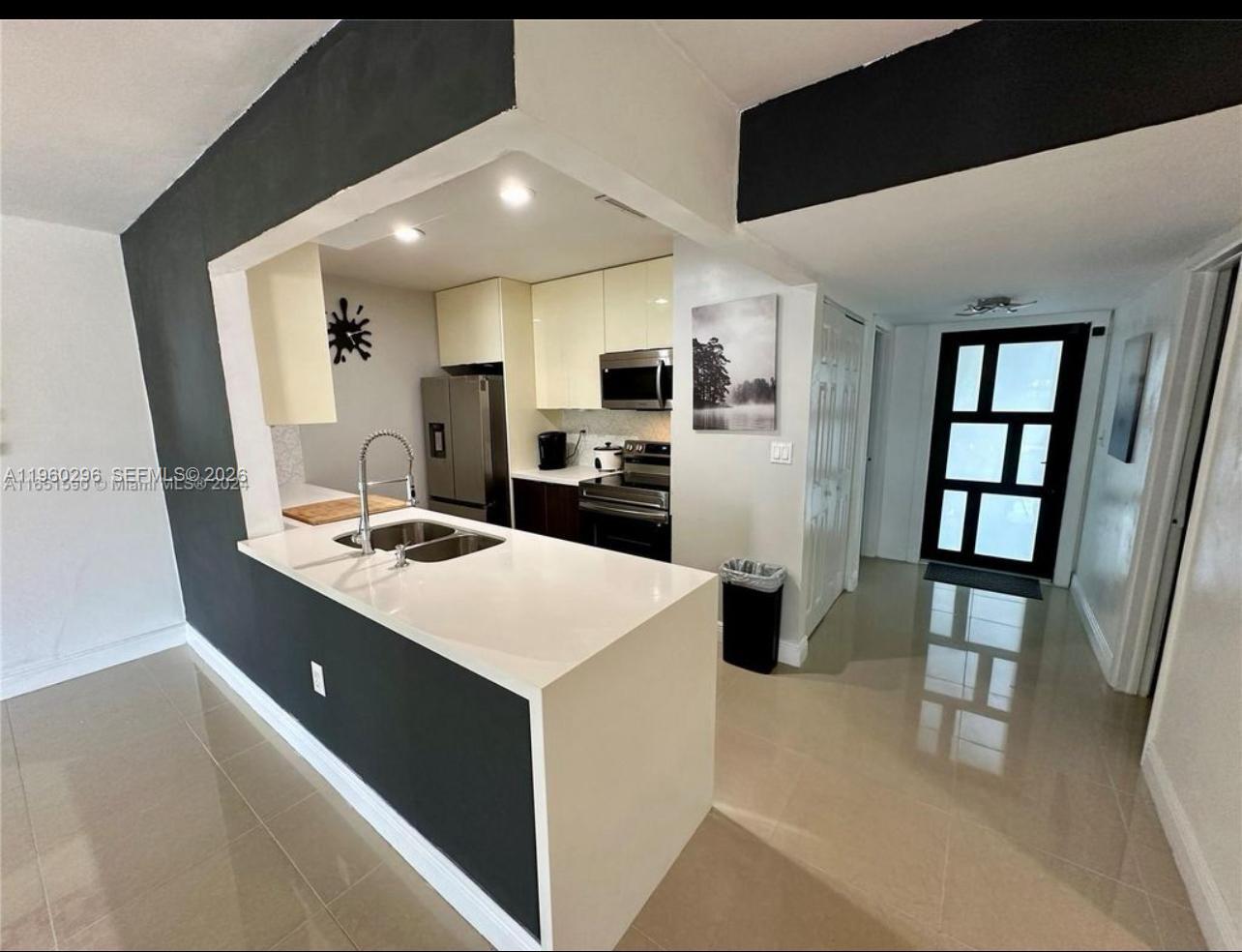 a kitchen with stainless steel appliances a stove refrigerator sink and white cabinets