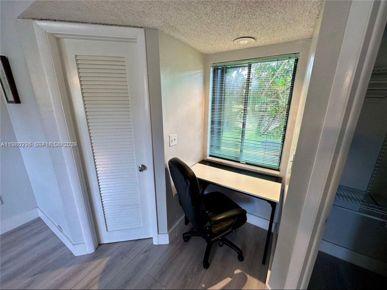10640 Southwest 75th Lane Miami, FL 33173 - Photo 13 of 21 a view of a workspace room with wooden floor and windows