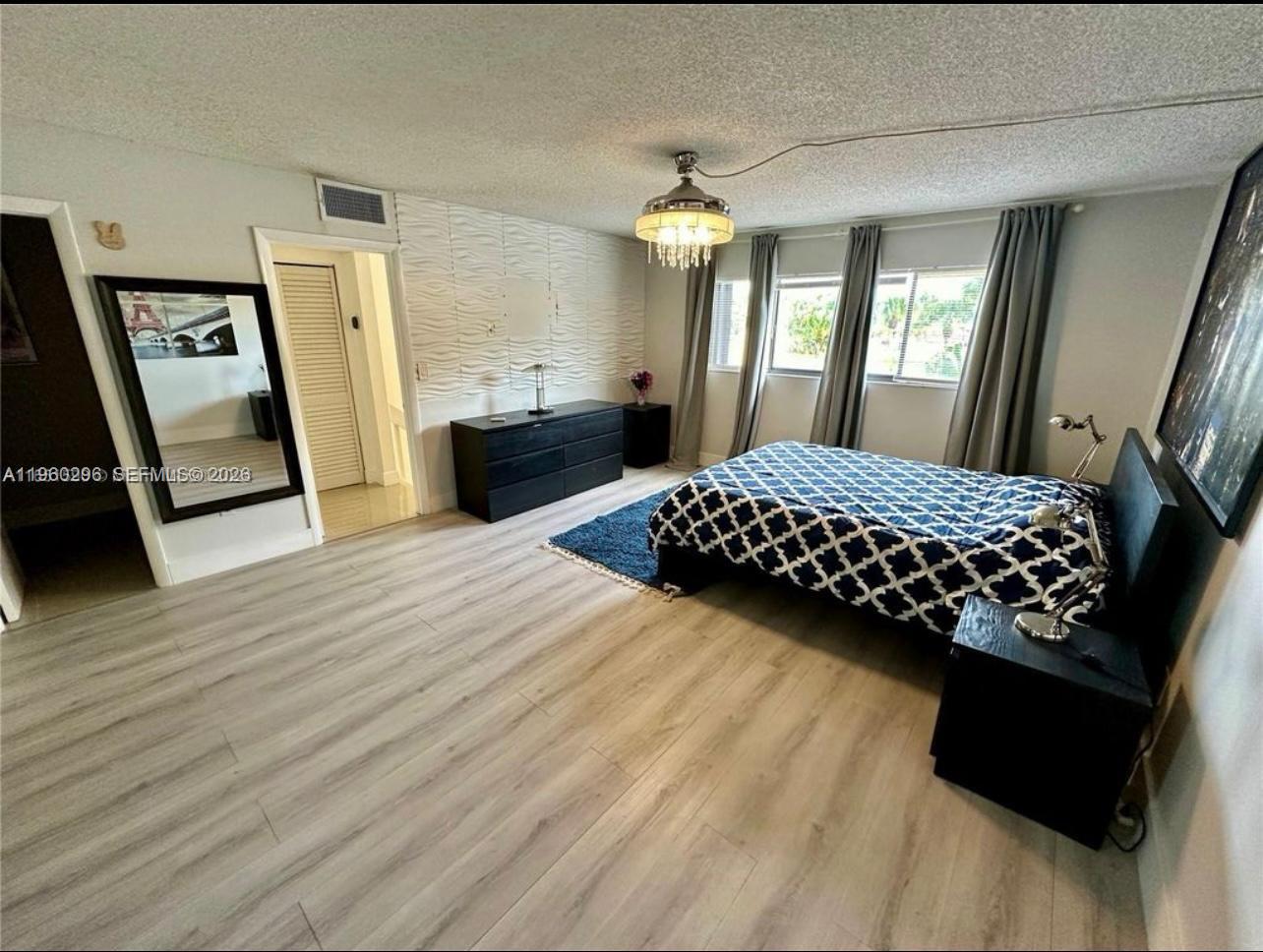 10640 Southwest 75th Lane Miami, FL 33173 - Photo 14 of 21 a bedroom with a bed window and wooden floor