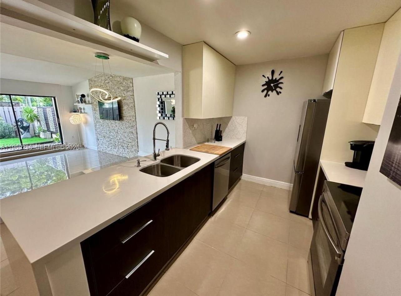 10640 Southwest 75th Lane Miami, FL 33173 - Photo 6 of 21 a kitchen with granite countertop a sink stove and refrigerator