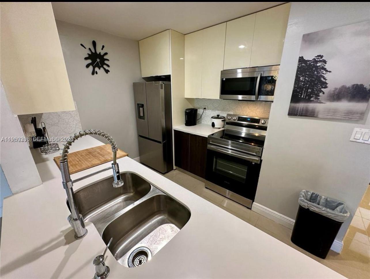 10640 Southwest 75th Lane Miami, FL 33173 - Photo 8 of 21 a kitchen with stainless steel appliances a stove a refrigerator and a sink