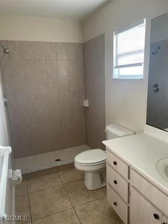 a bathroom with a granite countertop toilet and a sink