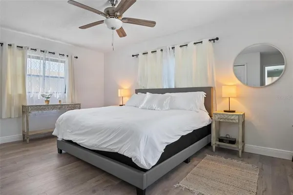 a large bed sitting in a room next to a window and a chandelier