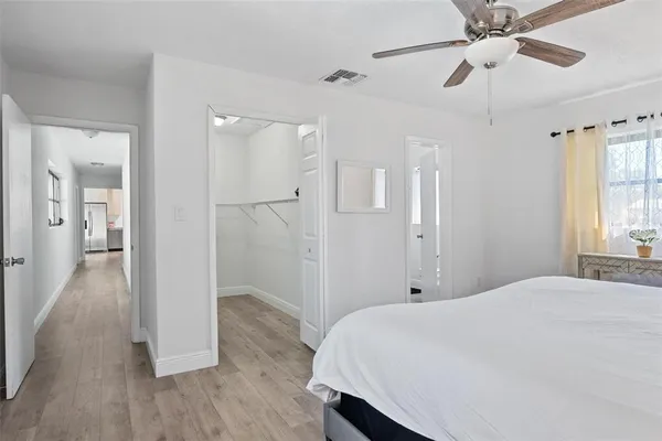 a bedroom with a bed and a chandelier fan