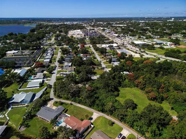 an aerial view of residential houses with outdoor space and trees