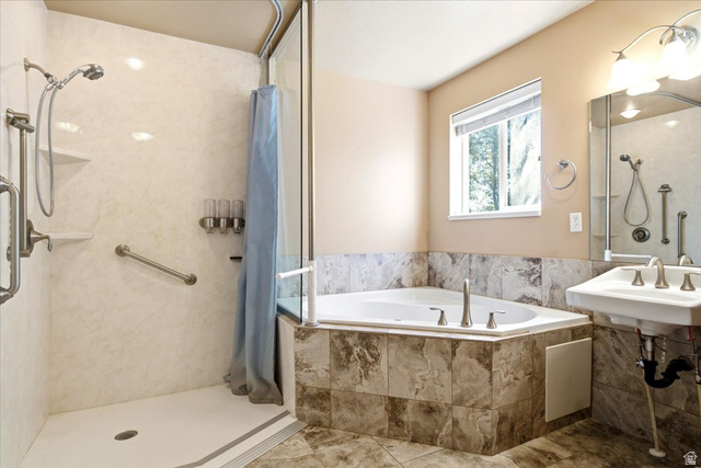 1089 West 2325th Street North Layton, UT 84041 - Photo 22 of 40 Bathroom featuring a tiled corner soaking tub, walk-in shower with grab bars and built-in shelving, pedestal sink with wall-mounted mirror, and overhead vanity lighting