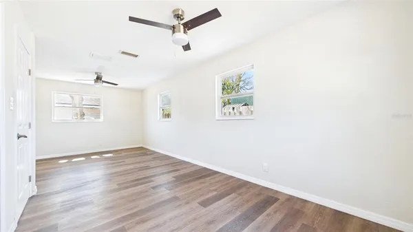 a view of empty room with wooden floor