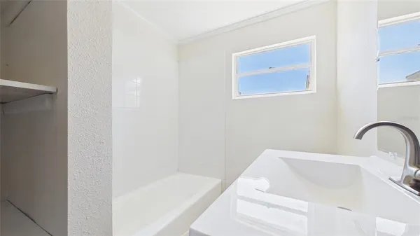 an empty room with a window and a ceiling fan