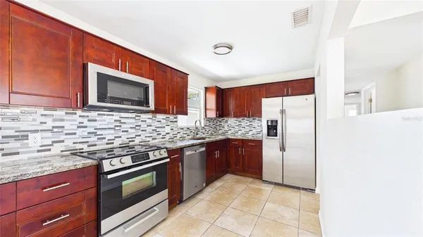 a kitchen with stainless steel appliances granite countertop a sink stove and cabinets