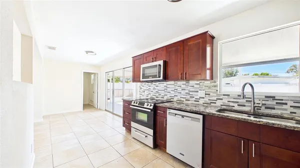 a kitchen with granite countertop a stove a washer and dryer