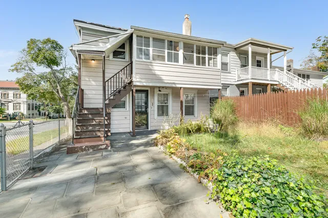 a front view of a house with a garden