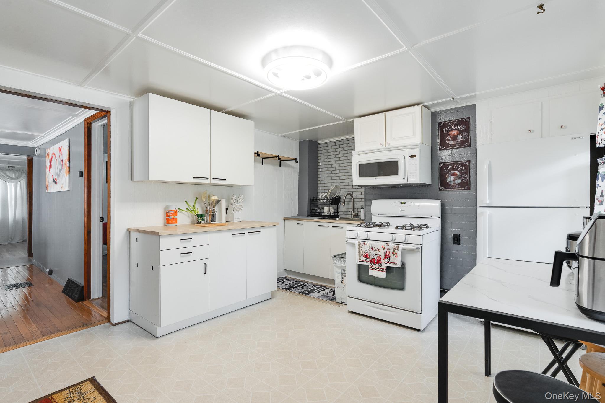 49 Delafield Street, Unit 1 Poughkeepsie, NY 12601 - Photo 5 of 24 a kitchen with white cabinets and white appliances