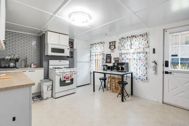 a view of kitchen with furniture and refrigerator