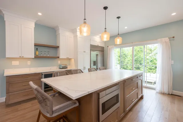 a kitchen with a stove a sink a center island and wooden floor