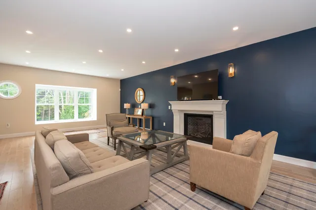 a living room with furniture a fireplace and a large window
