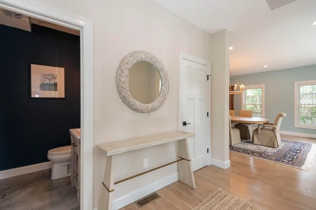 a living room with toilet a sink and a mirror