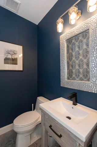 a bathroom with a sink mirror vanity and toilet