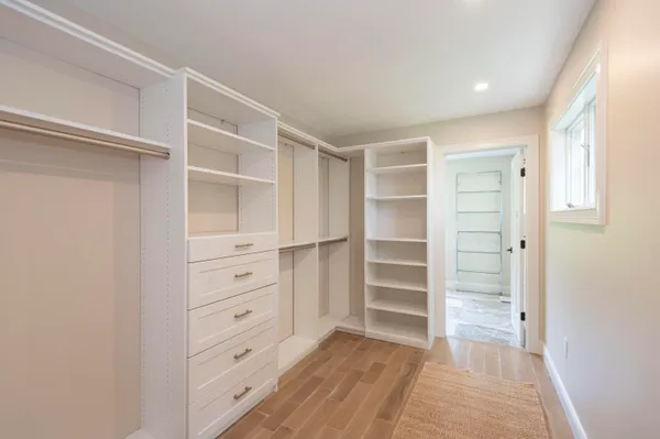 a view of walk in closet with empty racks