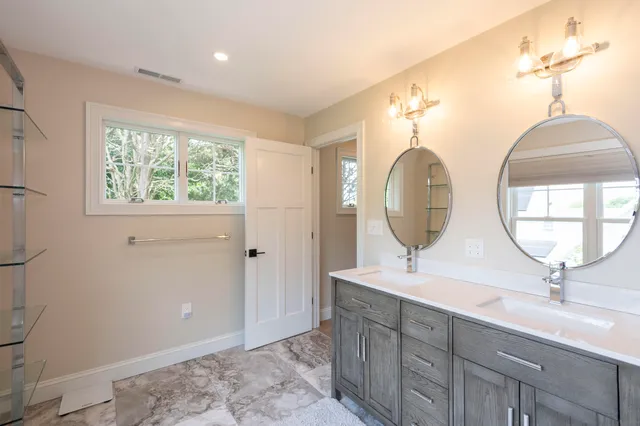 a bathroom with a double vanity sink and a mirror