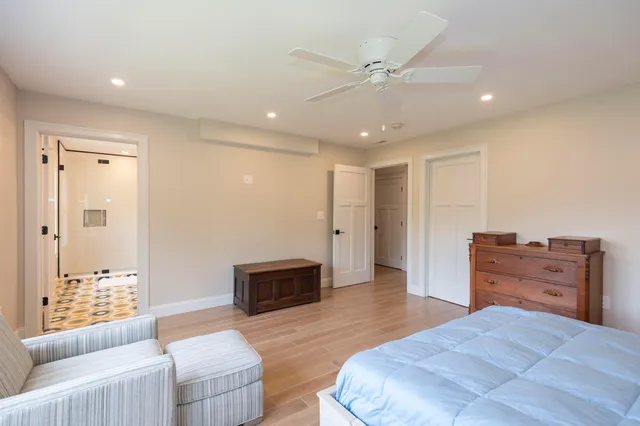 a spacious bedroom with a bed and wooden floor