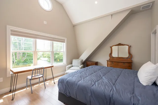 a bedroom with a bed and a large window