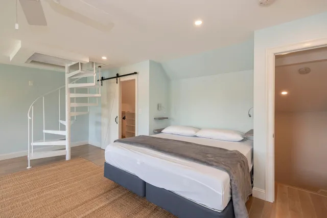a spacious bedroom with a bed and a view of closet