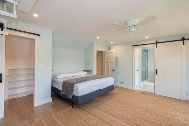 a spacious bedroom with a bed and a ceiling fan