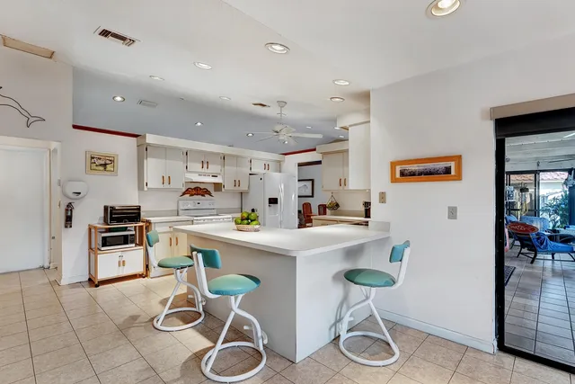a kitchen with furniture a refrigerator and chairs