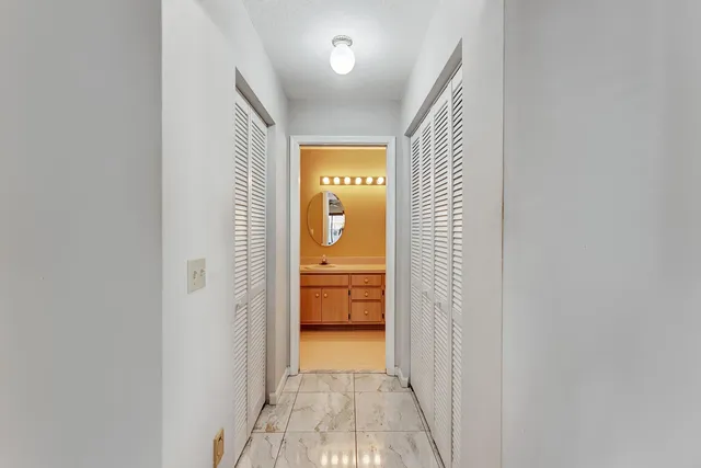 a view of a hallway with a livingroom and a bathroom with sink