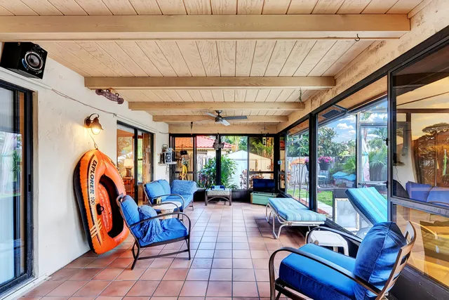 a living room with furniture a flat screen tv and a large window