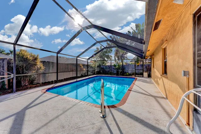 a view of a swimming pool with a patio and a yard