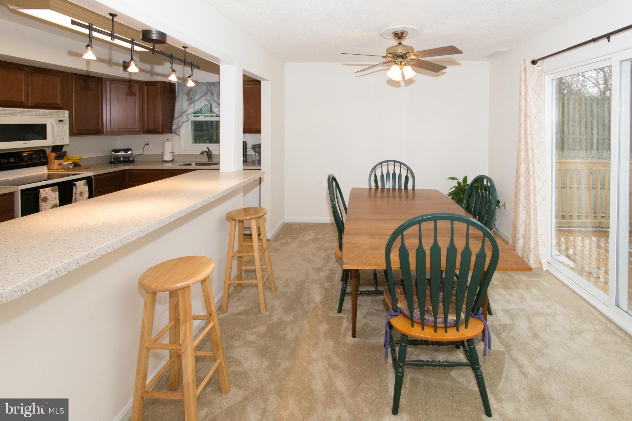 110 Oakwood Road Edgewater, MD 21037 - Photo 11 of 23 a kitchen with a dining table chairs and a refrigerator