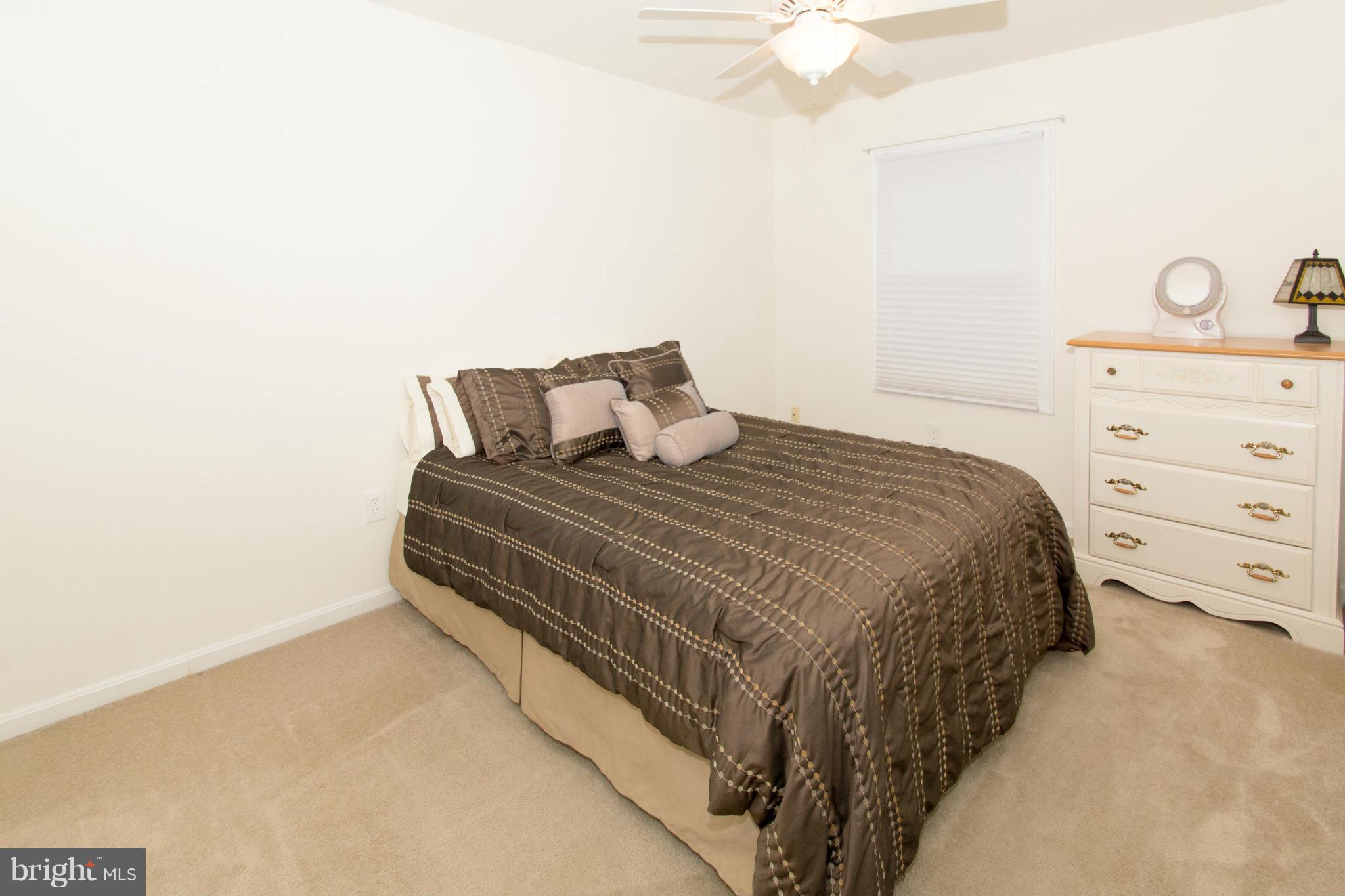 110 Oakwood Road Edgewater, MD 21037 - Photo 17 of 23 a bedroom with a bed and a chandelier fan