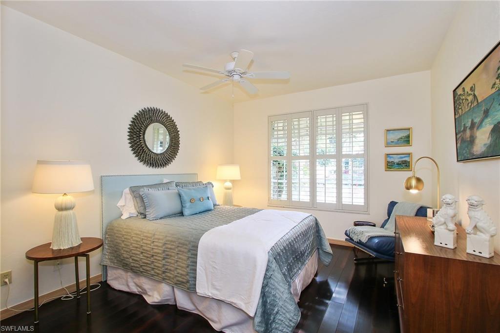 211 Via Napoli Naples, FL 34105 - Photo 12 of 23 a bedroom with a bed and a lamp next to a window