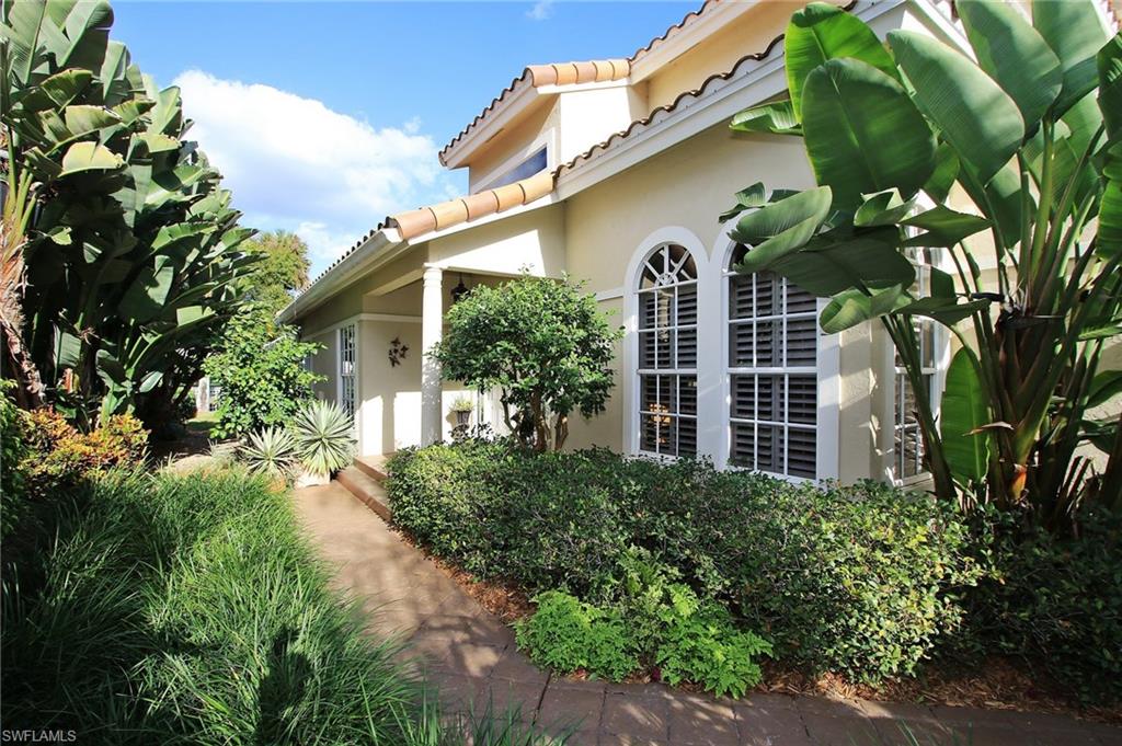 211 Via Napoli Naples, FL 34105 - Photo 15 of 23 a front view of a house with garden
