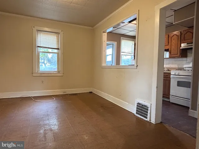 an empty room with a fireplace and wooden floor