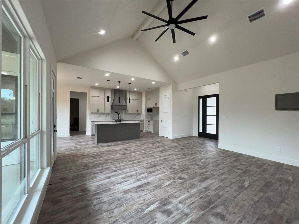 121 Cartwright Park Road Weatherford, TX 76087 - Photo 6 of 17 Spacious living area featuring wood-finish flooring, a vaulted ceiling with a modern ceiling fan, and recessed lighting