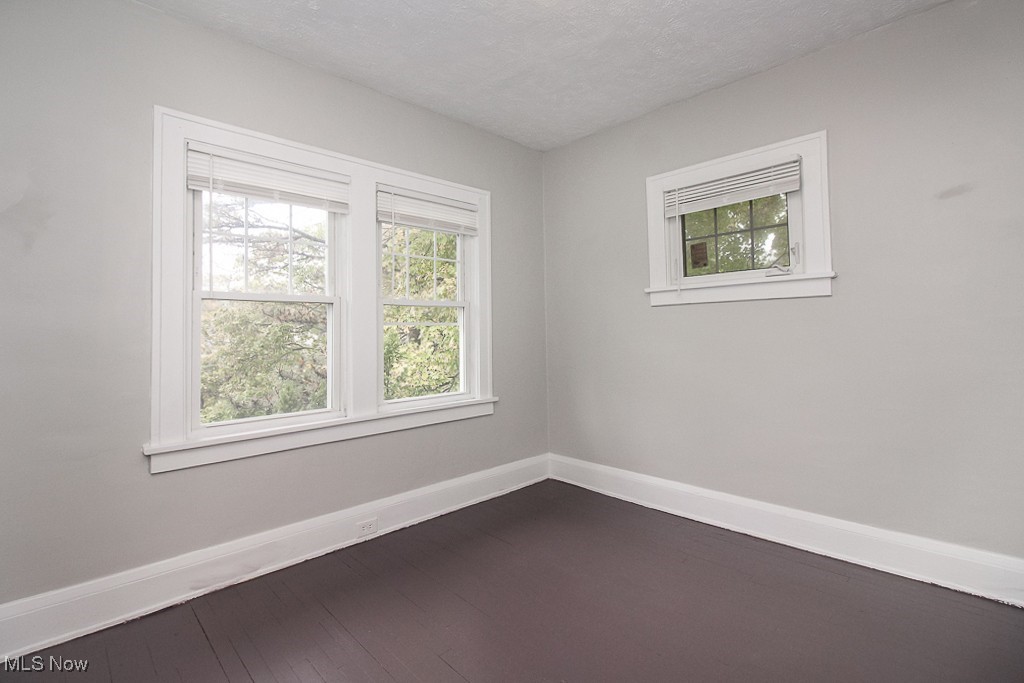 3085 Somerton Road Cleveland, OH 44118 - Photo 14 of 16 Empty room with dark wood finished floors, a textured ceiling, and baseboards