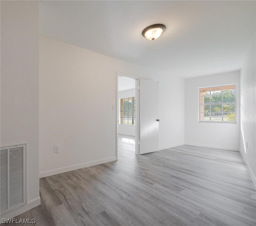 1850 Fort Denaud Road LaBelle, FL 33935 - Photo 19 of 37 an empty room with wooden floor and windows