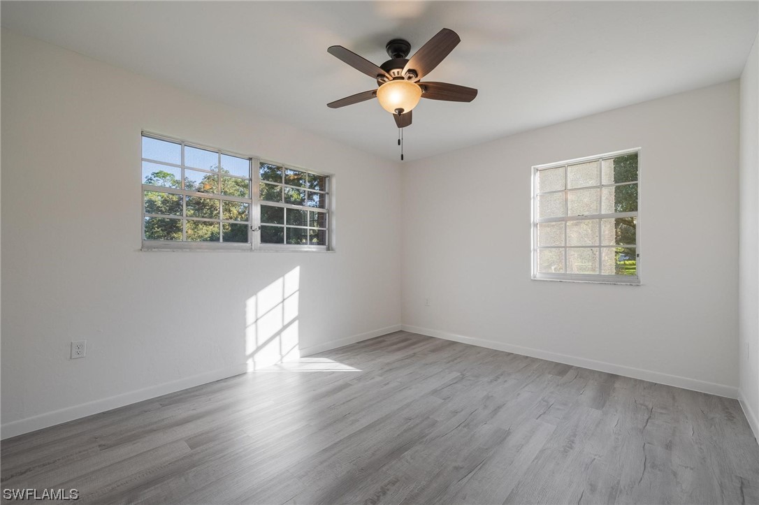 1850 Fort Denaud Road LaBelle, FL 33935 - Photo 24 of 37 wooden floor in an empty room with a window