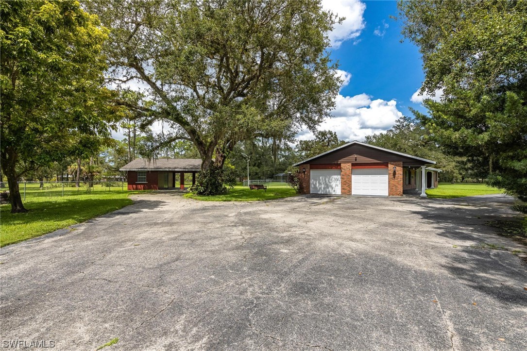 1850 Fort Denaud Road LaBelle, FL 33935 - Photo 33 of 37 a front view of a house with a yard and garage
