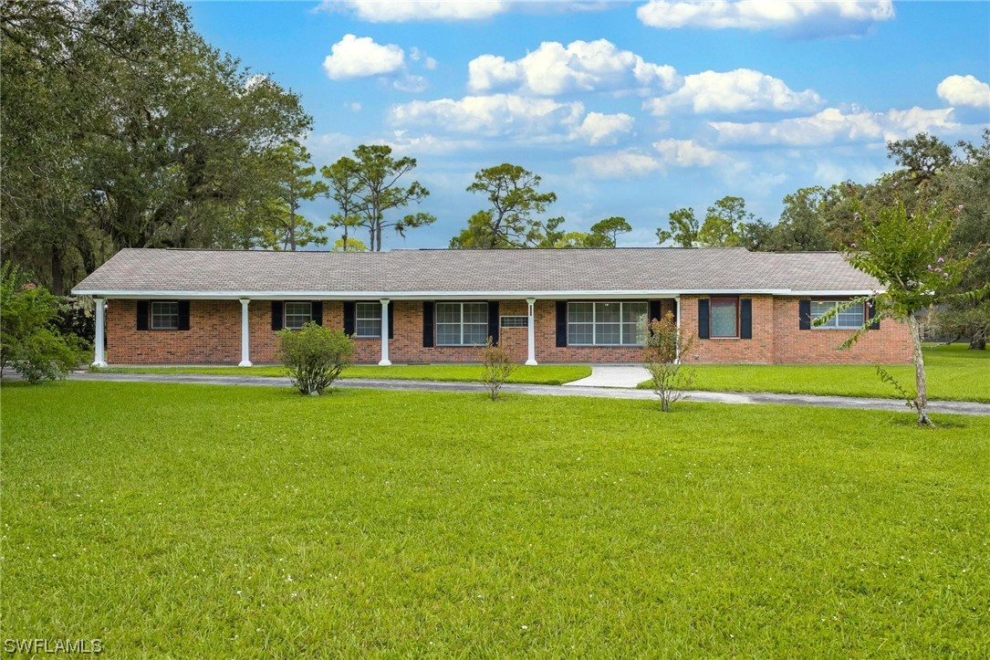 1850 Fort Denaud Road LaBelle, FL 33935 - Photo 4 of 37 a front view of a house with a garden