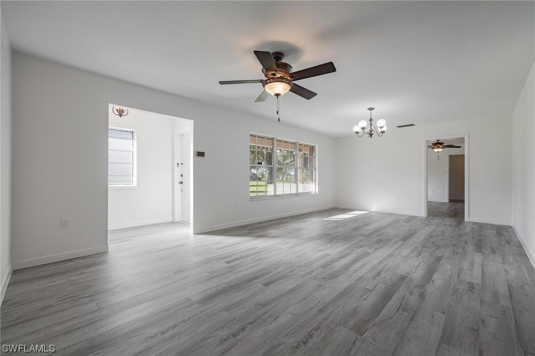 1850 Fort Denaud Road LaBelle, FL 33935 - Photo 7 of 37 an empty room with wooden floor ceiling fan and windows