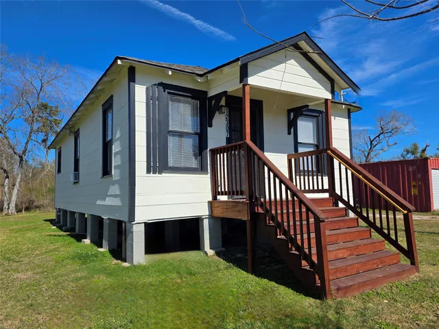 a view of a house with wooden fence and a porch